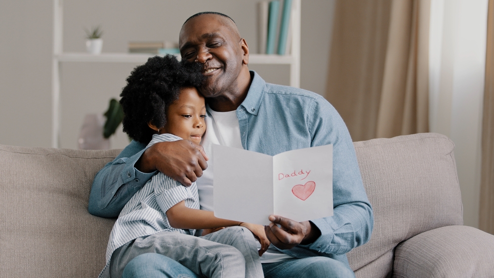Mature,African,American,Man,With,Cute,Kid,Girl,Hugging,Sitting